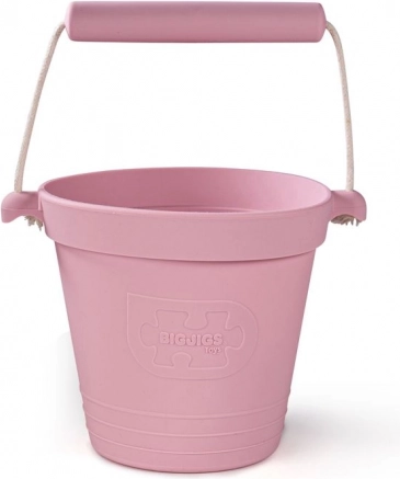 Šviesiai rožinis silikoninis paplūdimio kibirėlis BIGJIGS TOYS